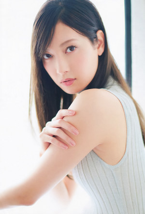 A woman in a blue shirt and jeans posing for a picture.