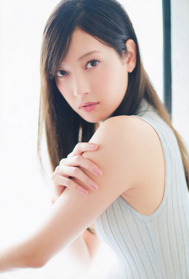 A woman in a gray tank top posing for a picture.