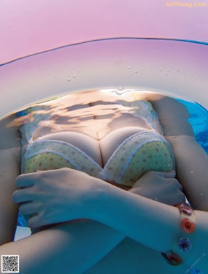 A woman in a bikini laying on the edge of a pool.