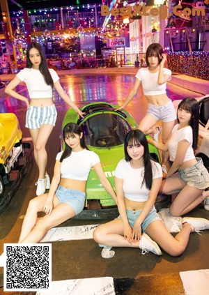 A group of young women standing next to each other near a pool.