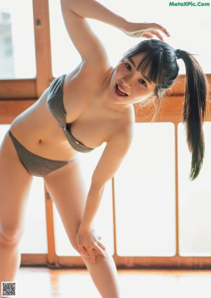 A woman laying on top of a bed next to a wall.