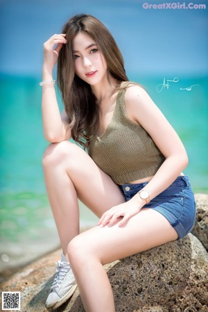 A woman standing on a beach next to the ocean.