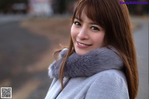 A woman wearing a black turtle neck sweater and a white bra.