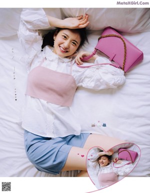 A woman laying on a bed reading a book.