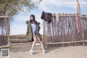 A woman sitting on top of a wooden fence next to a child.