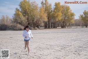 A woman sitting on the ground with her legs crossed.