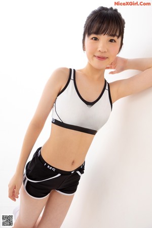 A woman in a black and white sports bra top and shorts.