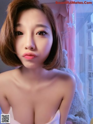 A woman in a white bra top holding a teddy bear.
