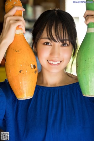 A woman in a blue dress holding a lemon.