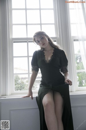 A woman in lingerie standing in front of a window.