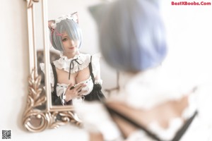 A woman with blue hair is sitting on a bed.