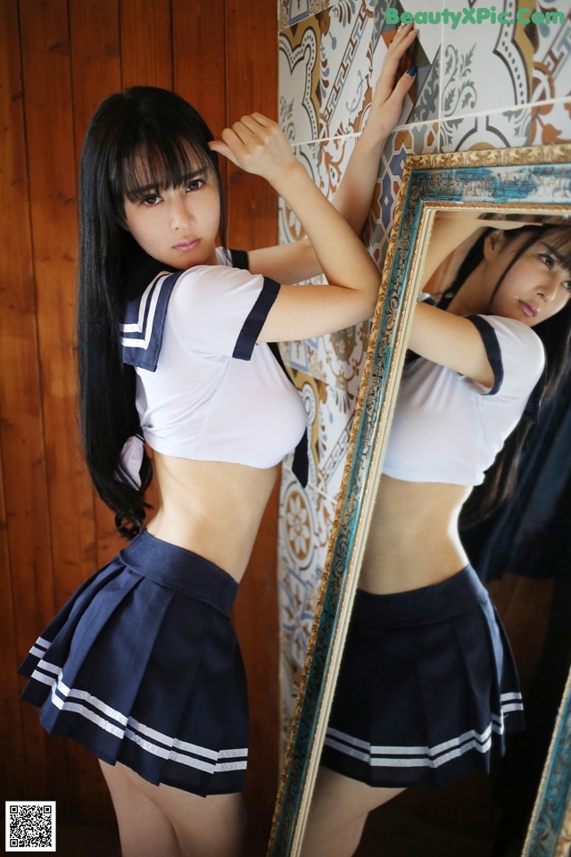 A woman in a school uniform posing in front of a mirror.