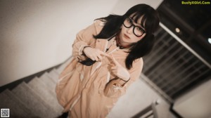 A woman wearing glasses and stockings sitting on a wooden bench.