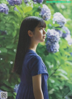 A young woman sitting on the floor wearing a green shirt.