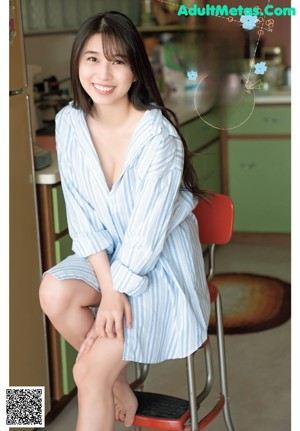 A woman sitting on a chair in a kitchen.