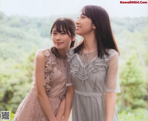 A couple of women standing next to each other in a field.