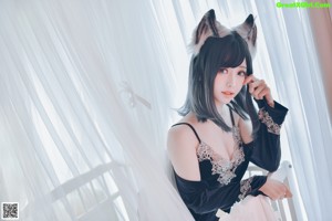 A woman in a black dress with a wolf ears on her head.