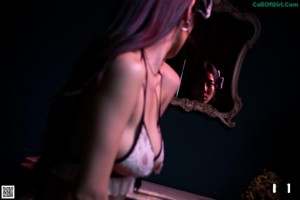 A woman in lingerie looking at herself in a mirror.