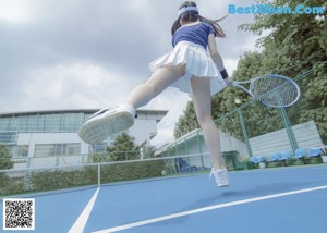 A woman in a blue and white uniform is sitting on the ground.