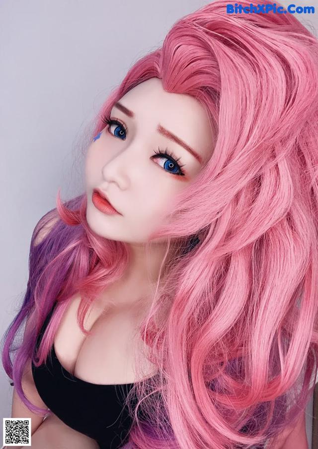 A doll with long pink hair and blue eyes.