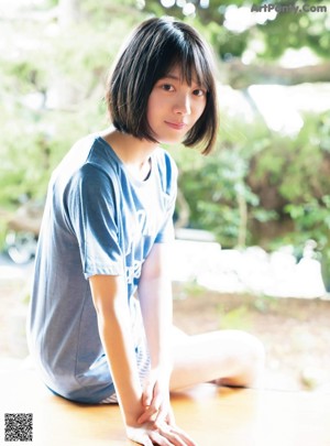 A woman in a school uniform holding a shell.