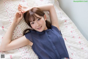 A woman in a blue shirt is posing for a picture.
