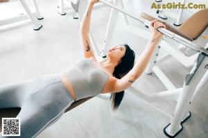 A woman in a black bikini standing on a treadmill.