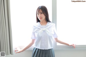 A woman in a school uniform posing for a picture.
