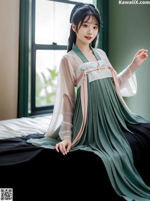 A woman in a blue and white hanbok sitting on a bed.